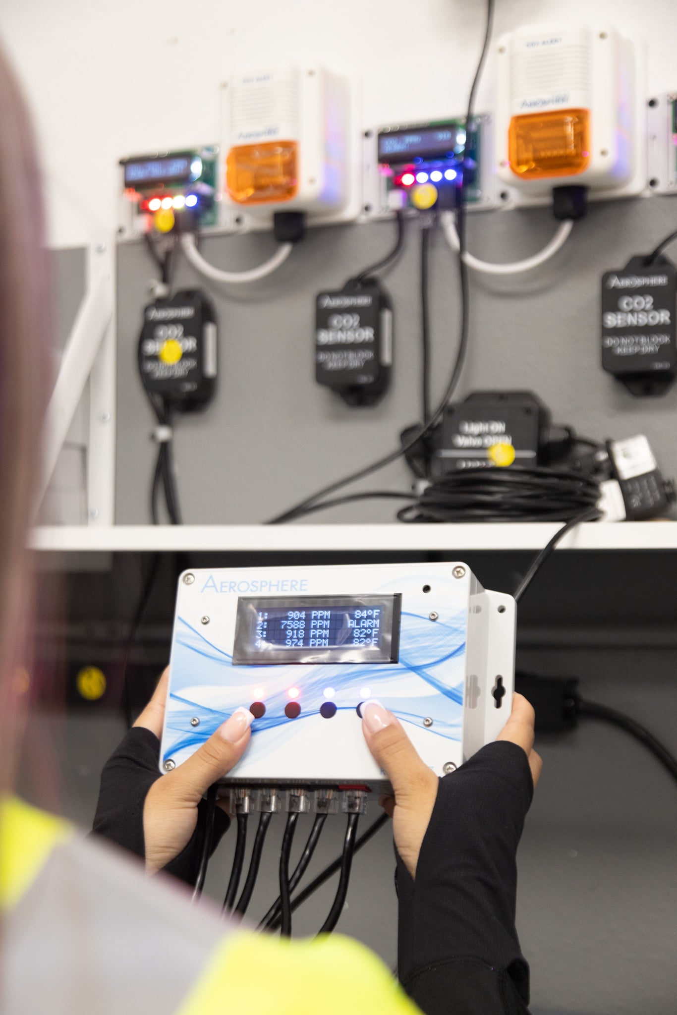 Staff member holding an Aerosphere CO2 Primary Monitor
